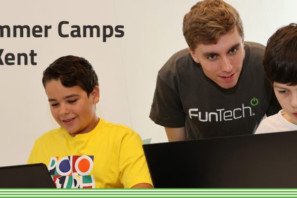 Summer Camps in Kent: 2 young boys on laptops with FunTech tutor standing over shoulder teaching.